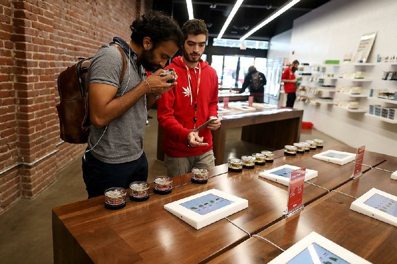 A sales assistant shows a customer flower strains of marijuana at MedMen, a marijuana and marijuana products retail store, in Los Angeles in 2018. 