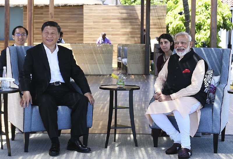 Chinese President Xi Jinping (left) meets Saturday with Indian Prime Minister Narendra Modi in Mamallapuram, India, in this photo provided by India’s Press Information Bureau. The two leaders resolved to work together in the face of radicalization and terrorism, a Modi aide said. 