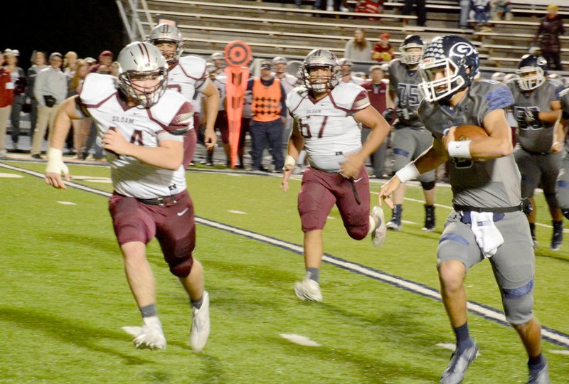 Graham Thomas/Siloam Sunday Siloam Springs junior Hunter Dorsey and sophomore J.P. Wills give chase as Greenwood quarterback Jace Presley runs with the ball during Friday's game at Smith-Robinson Stadium in Greenwood. Greenwood defeated Siloam Springs 43-13.