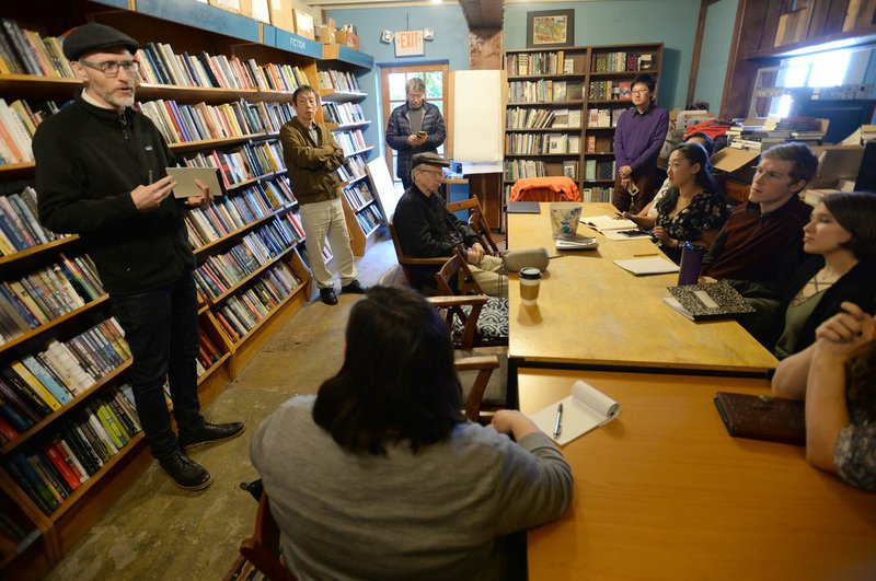 NWA Democrat-Gazette/ANDY SHUPE Jonathan Stalling (left), a poet and professor of English at the University of Oklahoma, speaks Saturday during a poetry workshop at Nightbird Books in Fayetteville that's part of a tour meant to unite U.S. and Chinese poets.