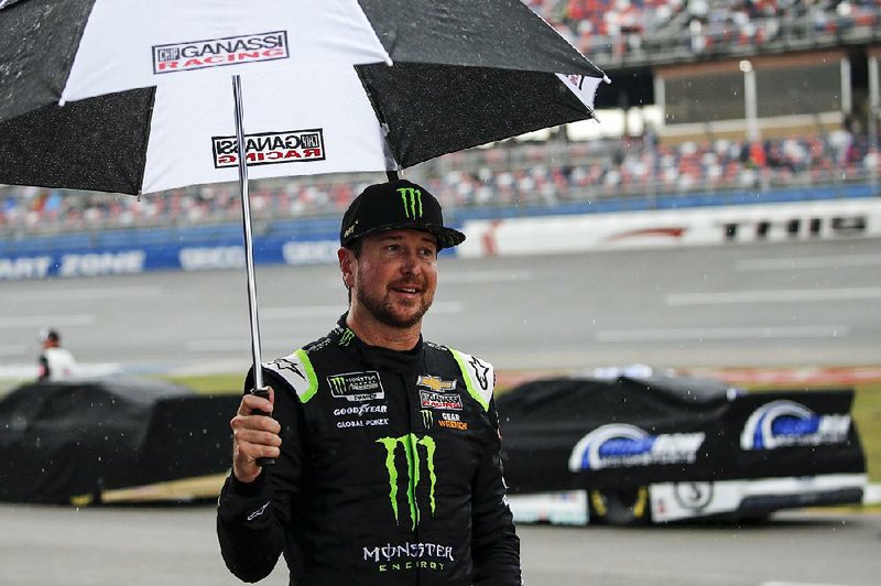 Kurt Busch walks back to garage during a rain delay in Sunday’s NA- SCAR Cup Series race at Talladega Superspeedway in Talladega, Ala. The race was postponed to today after the first stage.