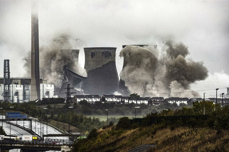 Cooling towers at the Ferrybridge Power Station in West Yorkshire, England, are shown Sunday as they’re demolished in a controlled explosion. 