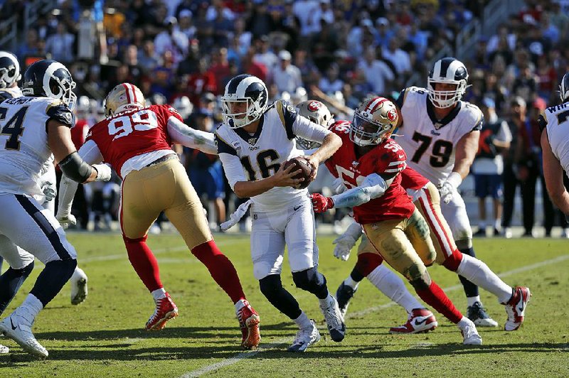 Los Angeles Rams quarterback Jared Goff (left) is pressured by San Francisco 49ers middle linebacker Kwon Alexander (56) during the second half Sunday in Los Angeles. Goff went 13 of 24 for a career-low 78 yards as the 49ers won 20-7.