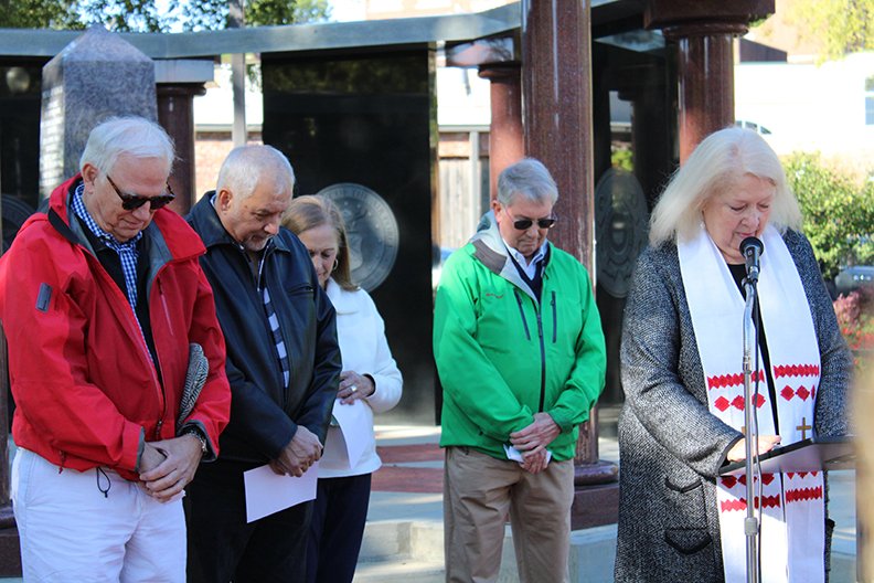 Carolyn Yeldell Staley, right, leads the Hot Springs High School Class of 1964 in prayer during a memorial service Saturday to honor deceased classmates and those who died in Vietnam at the Veterans Memorial of Garland County near Transportation Depot. From left are classmates Jim French, Bruce Sigman, Sandra Wilson and Phil Jamison. - Photo by Tanner Newton of The Sentinel-Record