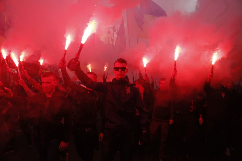 The Associated Press RED FLARES: Members of the nationalist movements light flares during a rally marking Defense of the Homeland Day in center Kyiv, Ukraine, Monday. Some 15,000 far-right and nationalist activists protested in the Ukrainian capital, chanting "Glory to Ukraine" and waving yellow and blue flags. President Volodymyr Zelenskiy urged participants to avoid violence and warned of potential "provocations" from those who want to stoke chaos.