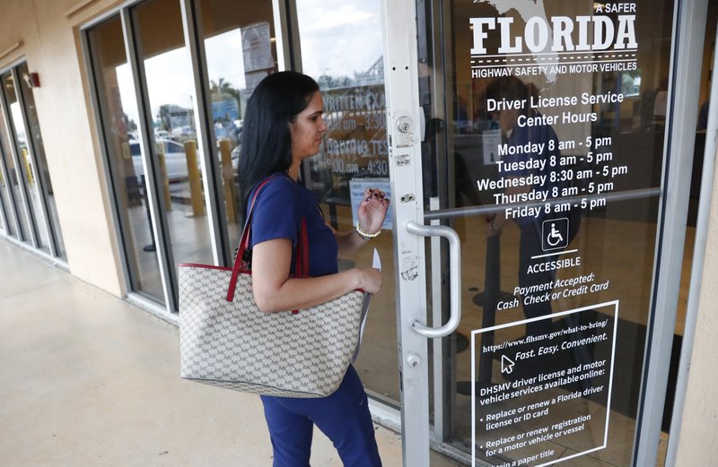 A woman enters a Florida Highway Safety and Motor Vehicles drivers license service center, Tuesday, Oct. 8, 2019, in Hialeah, Fla. The U.S. Census Bureau has asked the 50 states for drivers' license information, months after President Donald Trump ordered the collection of citizenship information. (AP Photo/Wilfredo Lee)