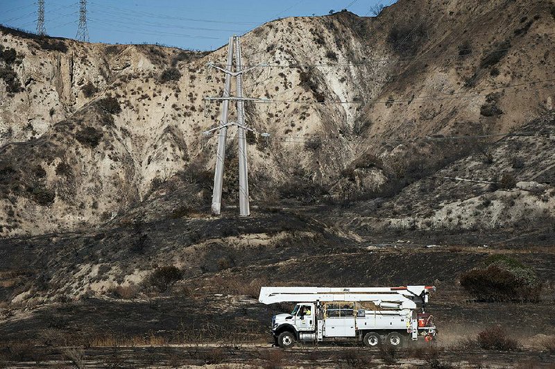 A SoCal Edison truck arrives Tuesday to inspect a transformer tower in Sylmar, Calif., suspected of being responsible for sparking a fire in the Southern California area last week. Meanwhile, a California utilities official blasted Pacific Gas & Electric over its recent planned power outage intended to reduce fire risk. More photos at arkansasonline.com/1016ca/ 