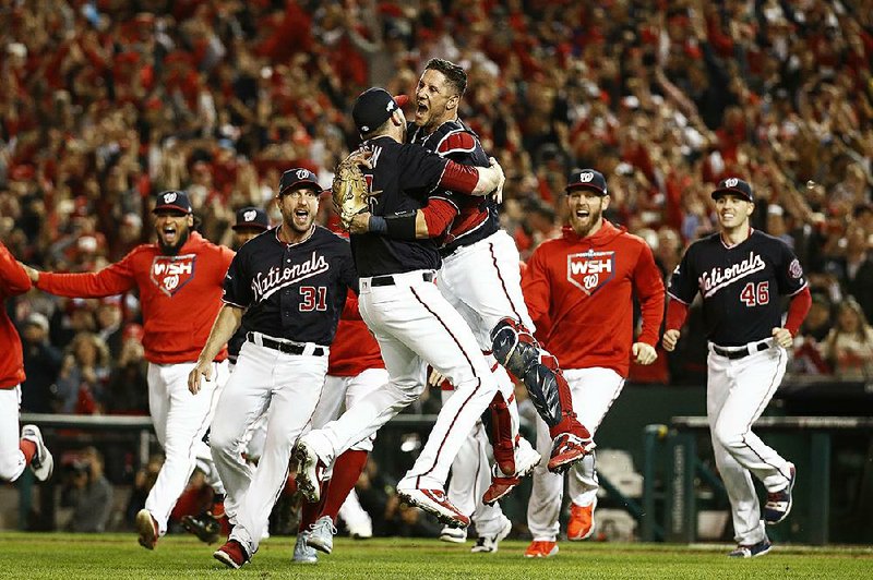 Washington Nationals catcher Yan Gomes leaps into the arms of pitcher Daniel Hudson to begin the celebration after their team defeated the St. Louis Cardinals in Game 4 of the National League Championship Series, sending the Nationals to their first World Series. 