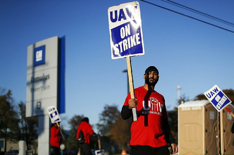 A member of the United Auto Workers walks the picket line last week at a General Motors plant in Romulus, Mich. GM Co. Chief Executive Officer Mary Barra met Tuesday with strike leaders at the bargaining table in Detroit. 