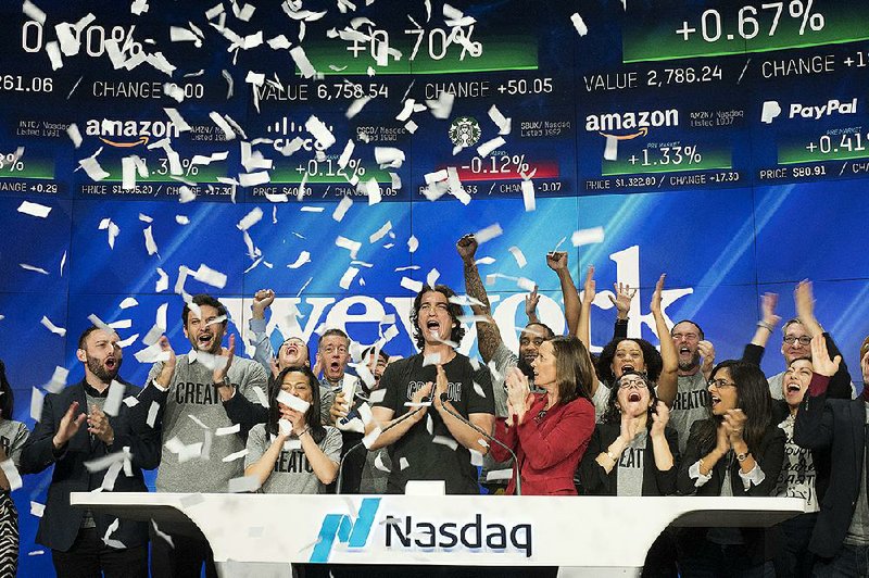 WeWork co-founder and CEO Adam Neumann (center) attends an opening bell ceremony in January 2018 at the Nasdaq stock exchange in New York. WeWork halted an initial public offering last month after investors spurned the deal. 