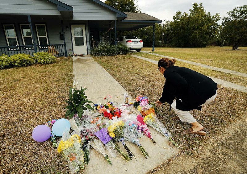 Anastasia Gonzalez of Burleson, Texas, leaves flowers Tuesday on the sidewalk in front of Atatiana Jefferson’s home in Fort Worth. More photos are available at arkansasonline.com/1016texas/ 
