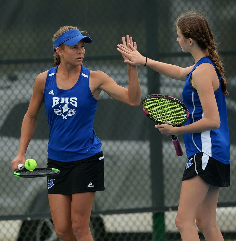 Rogers’ Grace Lueders (left) and Jenna Bohnert celebrate a point during their doubles match with Bentonville West’s Sarah Schneringer and Kristyn Tappana in the Class 6A state tennis championship Tuesday at Har-Ber High School in Springdale. Lueders and Bohnert won 6-3, 2-6, 6-4. For more photos, go to www.arkansasonline.com/1016tennis/. 