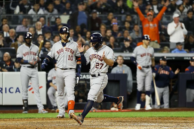 Houston second baseman Jose Altuve (27) claps his hands Tuesday after scoring on a wild pitch during the seventh inning of the Astros’ 4-1 victory over the New York Yankees in Game 3 of the American League Championship Series at Yankee Stadium. 