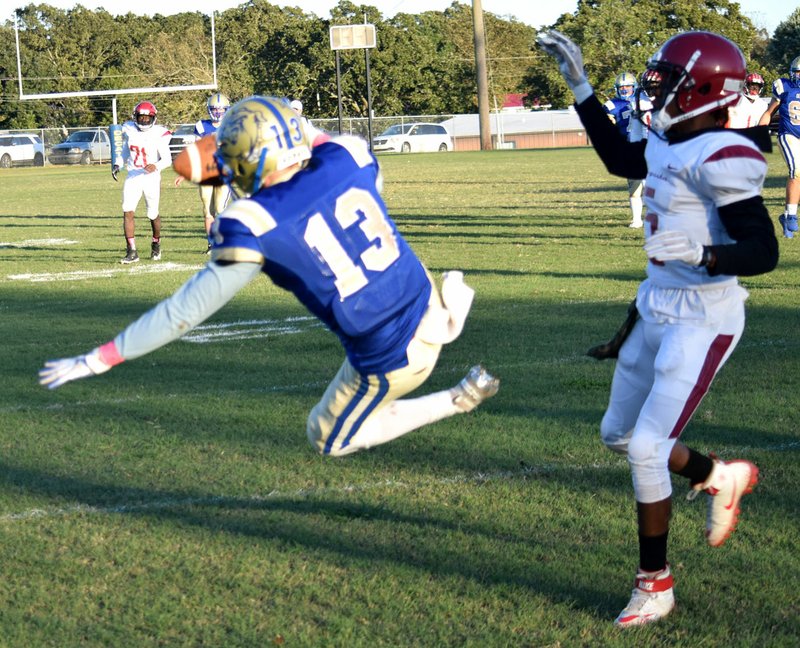 Westside Eagle Observer/MIKE ECKELS Sam Philpot (Decatur 13) was knocked off his feet by a Red Devil defender in the end zone while trying to catch a pass during the Oct. 11 Decatur-Augusta eight-man football contest at Bulldog Stadium in Decatur. Augusta was assessed with a 15-yard pass interference penalty, allowing the Bulldogs a second chance at the end zone, which failed.