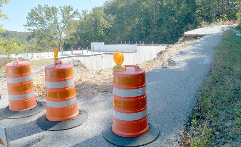 Keith Bryant/The Weekly Vista Sunset Drive remains closed as work continues in the space between it and U.S. Highway 71. The building's rear wall will serve as a retaining wall to help rebuild the slope the road sits on.
