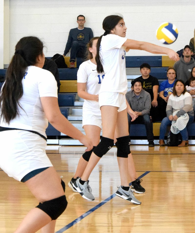 Westside Eagle Observer/MIKE ECKELS With Anette Hernandez (left foreground) as a backup, Giselle Fuentes (center) uses a forearm pass to send the ball back into Lady Highlander territory during the Decatur-Eureka Springs junior high volleyball match at the Decatur Middle School gym on Saturday. The Lady Bulldogs eliminated the Lady Highlanders in the first round.