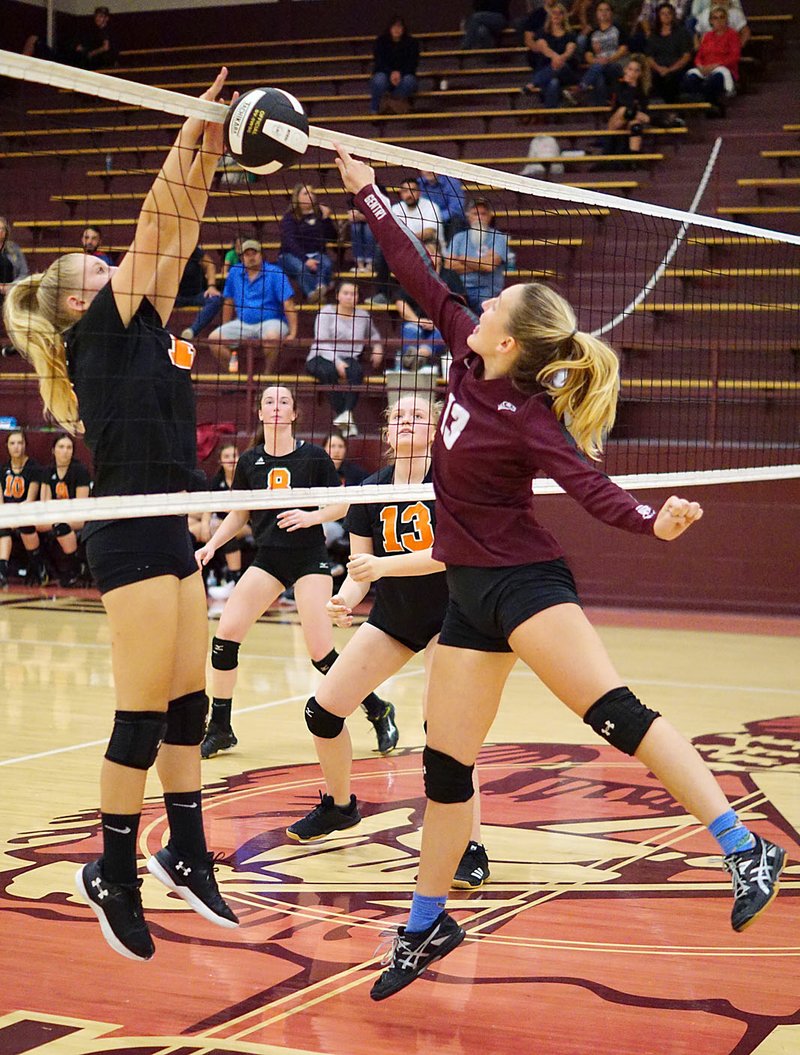 Westside Eagle Observer/RANDY MOLL While Gravette junior Makenna Davis blocks, Gentry senior Ariel Nix attempts to tip the ball over the net during play between the two teams at Gentry High School on Oct. 8.
