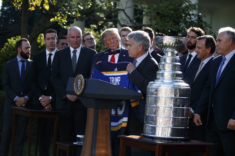 President Donald Trump is presented a team jersey by St. Louis Blues owner Tom Stillman during an event to honor the 2019 Stanley Cup Champion St. Louis Blues, in the Rose Garden of the White House, Tuesday, Oct. 15, 2019, in Washington. (AP Photo/Evan Vucci)