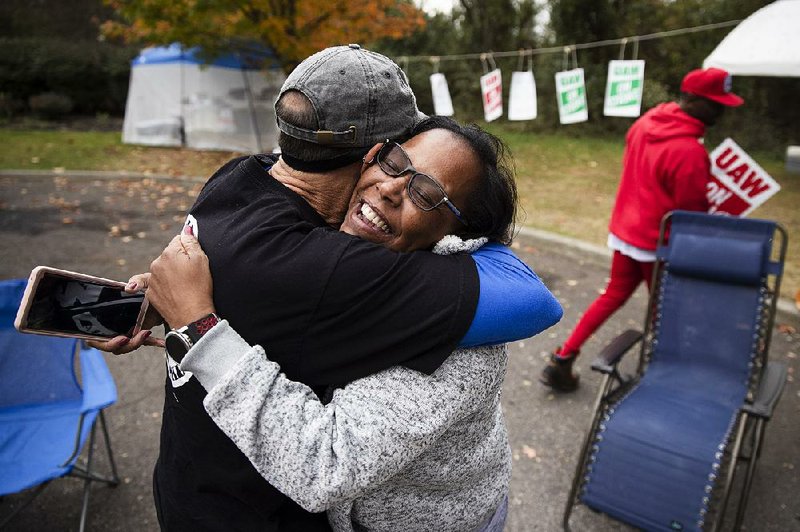 Picketing workers Richard Rivera and Robin Pinkney embrace Wednesday outside the General Motors plant in Langhorne, Pa., after hearing about a tentative deal. More photos at arkansasonline.com/1017strike/ 