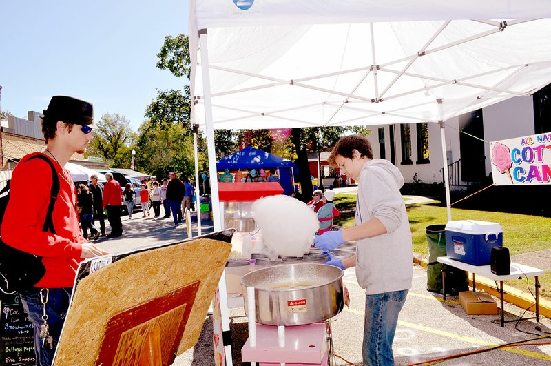 RACHEL DICKERSON/MCDONALD COUNTY PRESS Robert Thompson of Star City (right) makes cotton candy for a customer during the first Pineville Fall Festival on Saturday.