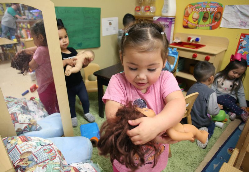 FILE PHOTO/DAVID GOTTSCHALK Abbygail Gonzalez plays with her doll in the Arkansas Better Chance Toddler Room at the Northwest Arkansas Sunshine School and Development Center in Little Flock. A Very Special Art Show on Nov. 7 at Record in Bentonville will benefit the school.