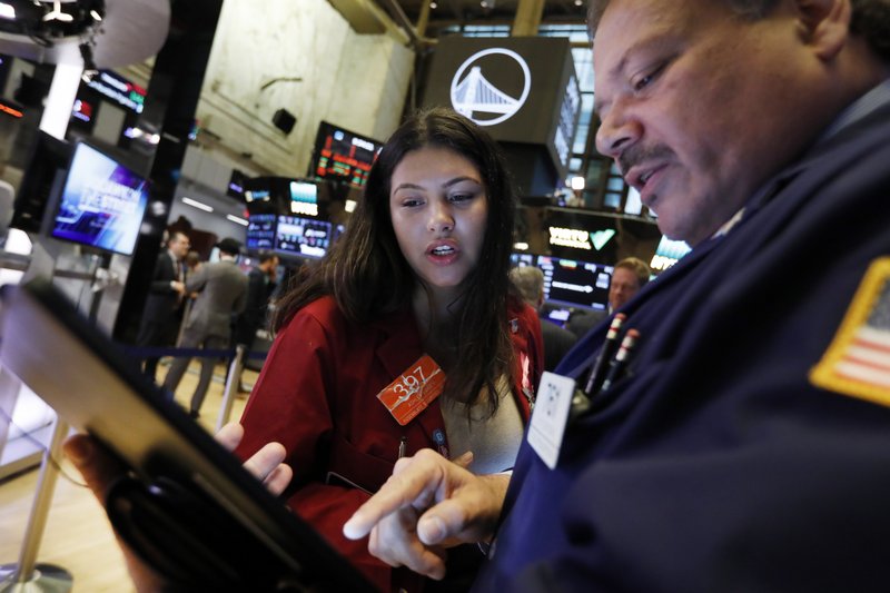 In this Oct. 7, 2019, file photo traders Ashley Lara and John Santiago confer as they work on the floor of the New York Stock Exchange.  (AP Photo/Richard Drew, File)