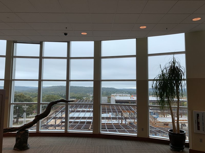 Construction of the Fayetteville Public Library expansion goes on outside the south-facing windows of the library looking out toward the Boston Mountains in the distance. The expansion is expected to open in October 2020.