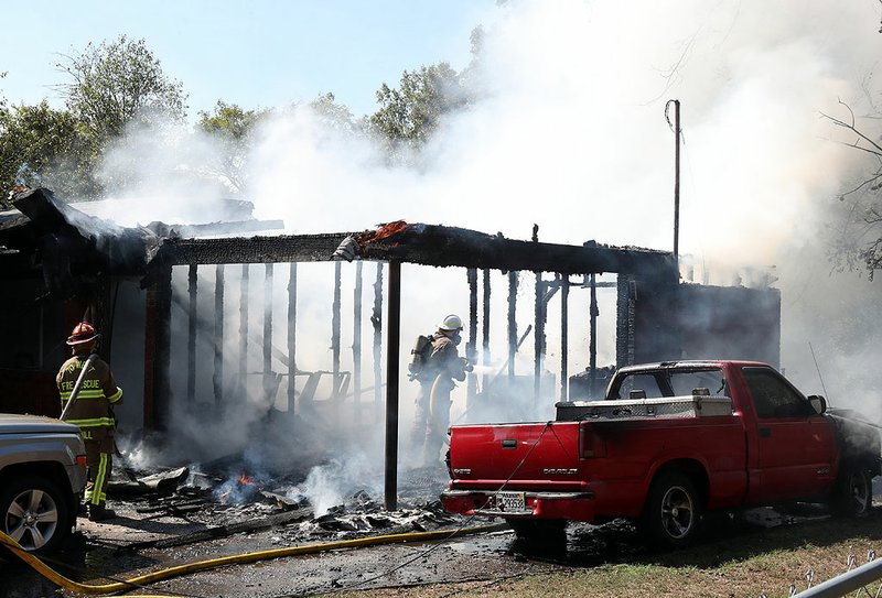 Firefighters from 70 West Fire Department battle a fire at 112 Mossyrock St. on Thursday. - Photo and video by Richard Rasmussen of The Sentinel-Record