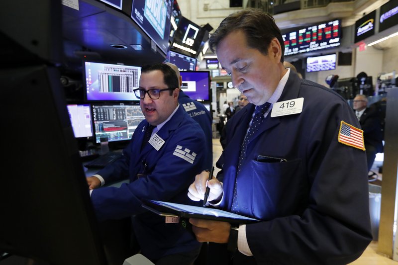 FILE - In this Oct. 8, 2019, file photo specialist Brian Fairbrother, left, and trader Philip Powers work on the floor of the New York Stock Exchange. The U.S. stock market opens at 9:30 a.m. EDT on Thursday, Oct. 17. (AP Photo/Richard Drew, File)