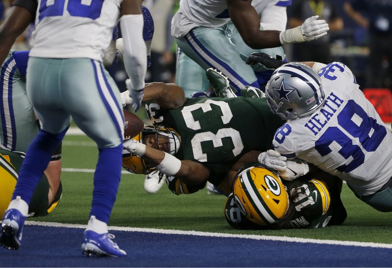 Green Bay Packers running back Aaron Jones (33) reaches over Jake Kumerow (16) and Dallas Cowboys' Jeff Heath (38) into the end zone for a touchdown in the second half of an NFL football game in Arlington, Texas, Sunday, Oct. 6, 2019. (AP Photo/Michael Ainsworth)