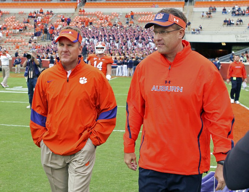 In this Sept. 17, 2011, file photo, then-offensive coordinators Chad Morris, left, of Clemson, and Gus Malzahn, right, of Auburn, walk together on the field at Memorial Stadium before an NCAA college football game, in Clemson, S.C. Morris is now the head coach at Arkansas. Malzahn is the head coach at Auburn. The two chat each week _ except when they play each other. (Mark Crammer/The Independent-Mail via AP, File)