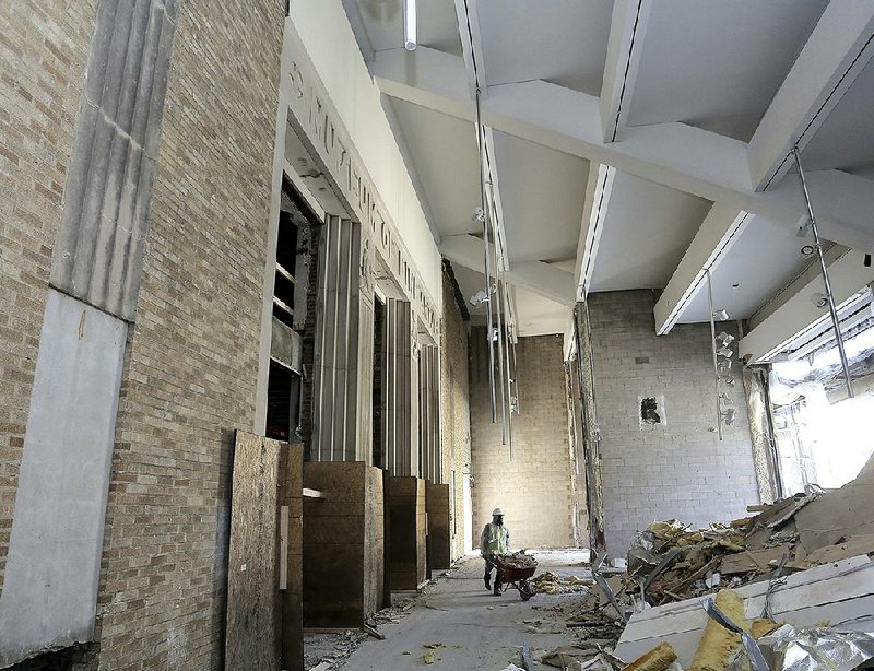 A workman removes construction debris Friday from the Arkansas Arts Center in Little Rock. At left is the center’s original facade from the 1930s, which will become a new museum entrance facing East Ninth Street. 