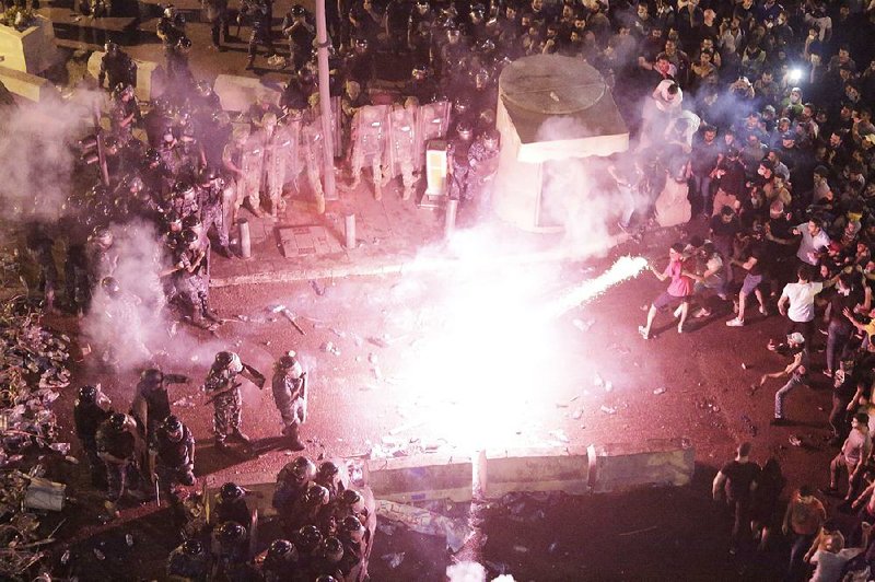 Anti-government protesters in Beirut, Lebanon, use fireworks against riot police Friday during a protest against the government’s plans to impose new taxes. More photos are available at arkansasonline.com/1019protest/. 