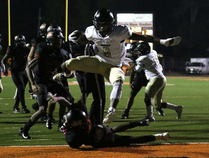 Joe T. Robinson running back Hunter Smith (6) leaps over Malvern defensive back Dante Reed (7) into the end zone for a touchdown during the second quarter of the Senators’ 46-7 victory. More photos available online at arkansasonline.com/1019robinsonmalvern/.