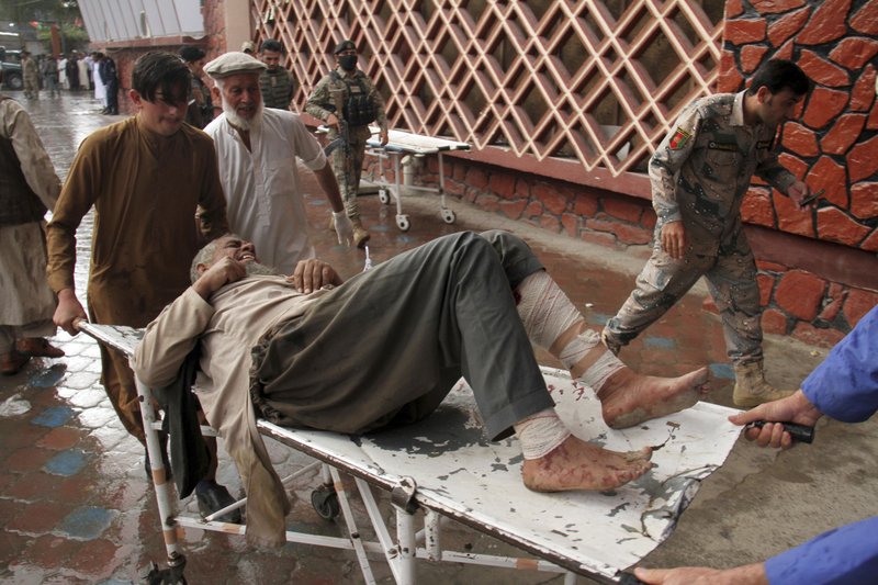 A wounded man is brought by stretcher into a hospital after a mortar was fired by insurgents in Haskamena district of Jalalabad east of Kabul, Afghanistan, Friday, Oct. 18, 2019. An Afghan official says at least several people have been killed during Friday prayers when a mortar fired by insurgents blasted through the roof of a mosque. (AP Photo/Wali Sabawoon)