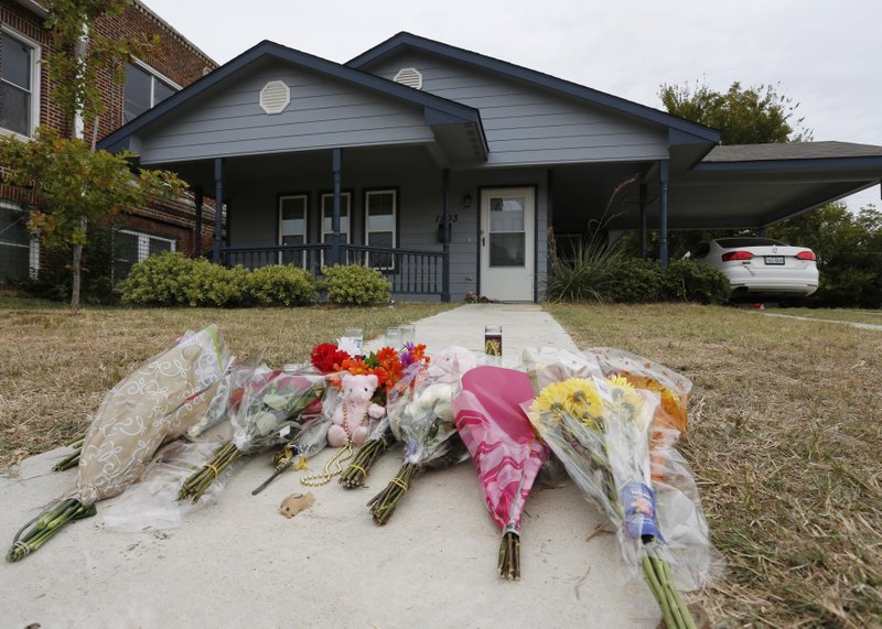 FILE - In this Monday, Oct. 14, 2019 photo, flowers lie on the sidewalk in front of the house in Fort Worth, Texas, where a white Fort Worth police officer Aaron Dean shot and killed Atatiana Jefferson, a black woman, through a back window of her home. Dean resigned before he could be compelled to undergo questioning. After a police officer fatally shoots someone, it can take days or even weeks before the public or his supervisors hear the officer&#x2019;s version of what happened. (AP Photo/David Kent, File)