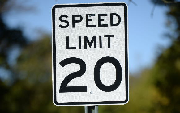 NWA Democrat-Gazette/ANDY SHUPE A 20-mph sign stands along Prospect Street north of Wilson Park in Fayetteville. The city installed 20-mph speed limit signs on residential streets near Wilson Park as a pilot program to test lower speed limits in neighborhoods with bike routes.