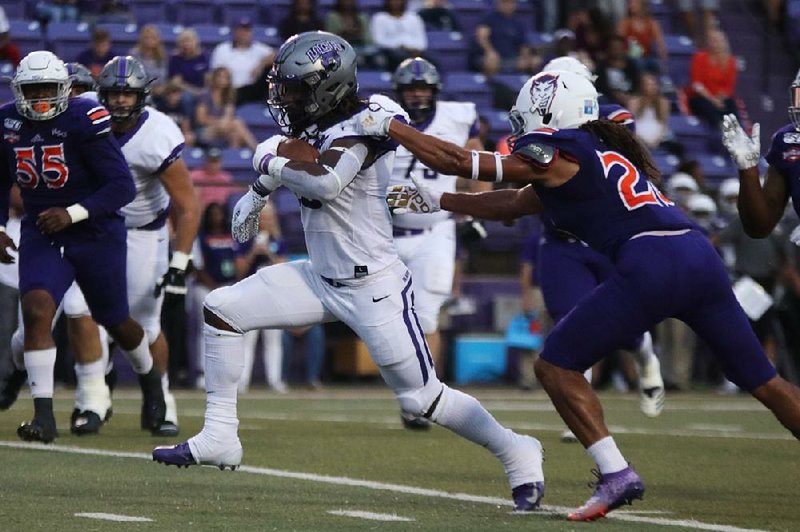 UCA running back Carlos Blackman runs through an arm tackle by a Northwestern (La.) State defender Saturday during the Bears’  31-30 victory over the Demons in Natchitoches, La. 