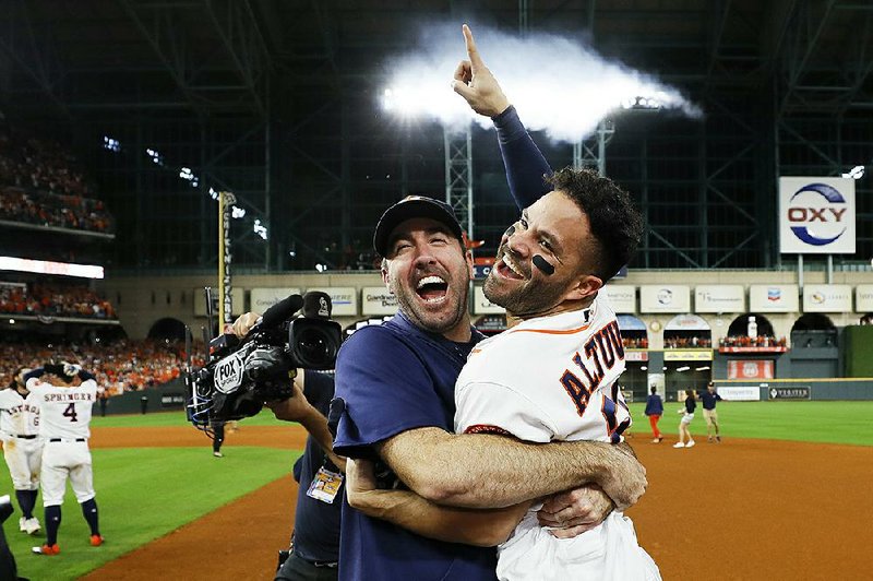 Jose Altuve (right) of the Houston Astros celebrates with teammate Justin Verlander after hitting  the game-winning home run against the New York Yankees in Game 6 of the American League Championship Series on Saturday night. With the victory, the Astros advance to the World Series. 