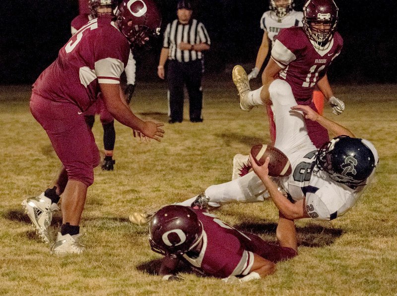 Bud Sullins/Special to Siloam Sunday A trio of Oaks-Mission (Okla.) players, Jordan Dry (left), Aaron Budder and Tiajer Russell, converge to tackle Summit Christian (Okla.) quarterback Wyatt Austin on Thursday at Tucker Field in Oaks. The Eagles defeated the Warriors 41-0.