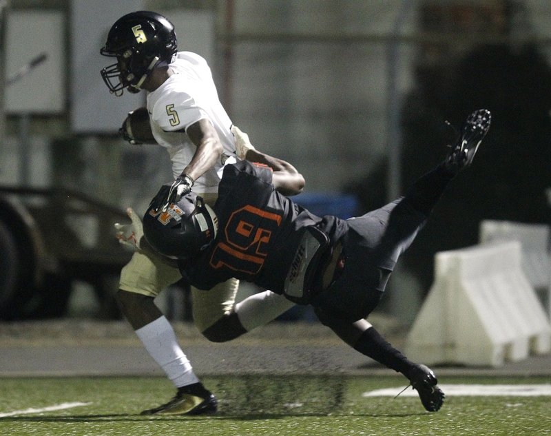 Joe T. Robinson wide receiver PJ Hall (5) shoves away Malvern defensive back Malique Reliford (19) during the first quarter of Robinson's win on Friday at Claude Mann Stadium in Malvern. Photo by Thomas Metthe of the Arkansas Democrat-Gazette