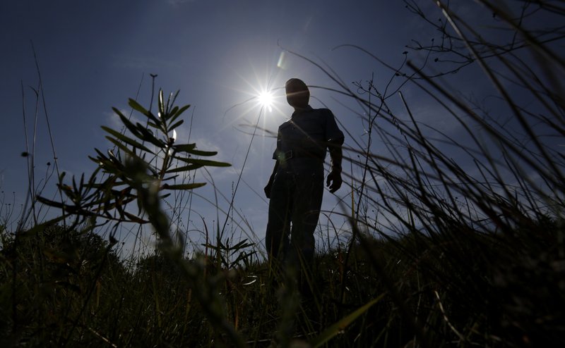 Andy Sansom walks on his property near the site of a proposed new natural gas pipeline would pass through his ranch in the Texas Hill Country near Stonewall, Texas Friday, Aug. 2, 2019. A proposed pipeline is a 430-mile, $2 billion natural gas expressway that pipeline giant Kinder Morgan has mapped from the booming West Texas oil patch to Houston. (AP Photo/Eric Gay)