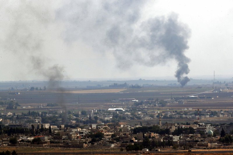 In this photo taken from the Turkish side of the border between Turkey and Syria, in Ceylanpinar, Sanliurfa province, southeastern Turkey, smoke billows from fires in Ras al-Ayn, Syria, Sunday, Oct. 20, 2019.  