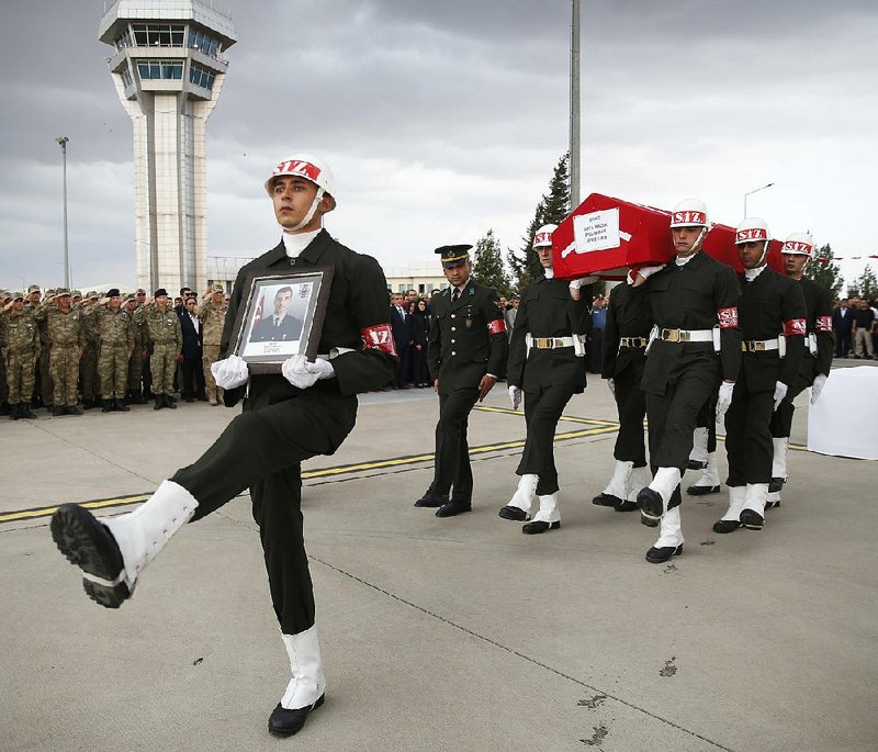 Turkish troops carry the flag-draped coffin of soldier Sefa Findik during a ceremony Sunday at the airport in Sanliurfa. Findik was killed earlier in the day — the seventh Turkish soldier killed in the offensive against Syrian Kurdish forces. Video is available at arkansasonline.com/1021syria/. 