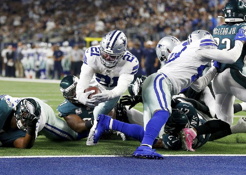 Dallas Cowboys running back Ezekiel Elliott leaps into the end zone for a touchdown in the first half against the Philadelphia Eagles on Sunday in Arlington, Texas. Elliott ran for 111 yards in Dallas’ 37-10 victory. 