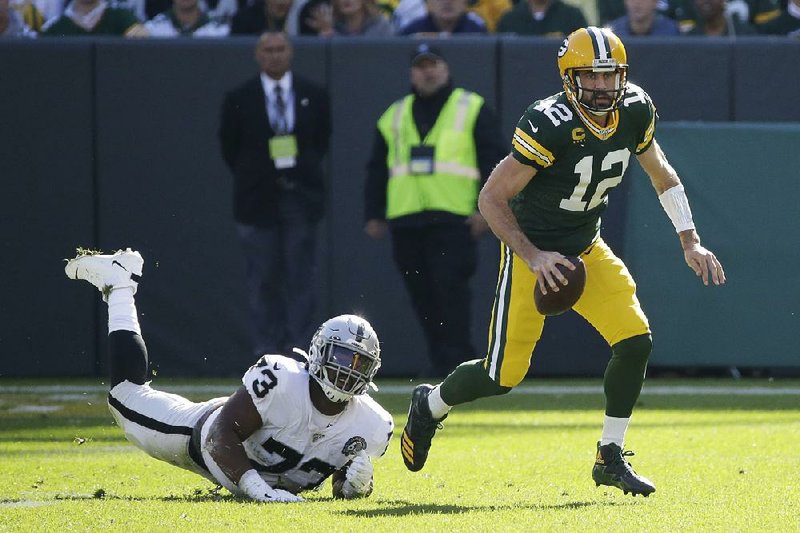 Green Bay’s Aaron Rodgers gets away from Oakland’s Maurice Hurst during the first half Sunday in Green Bay, Wis. Rodgers threw for 429 yards and 5 touchdowns and ran for another as Green Bay won 42-24. 