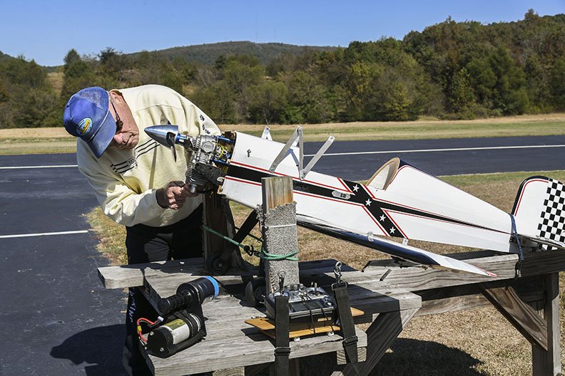 Hot Springs Radio Control Flying Club member Ed Crahan works on the engine of one of his RC planes Thursday at Cedar Glades Park.
