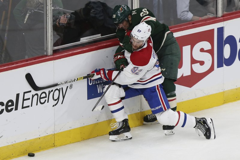 Montreal Canadiens' Jonathan Drouin (92) and Minnesota Wild's Gabriel Dumont (28) fight for possession of the puck in the third period of Sunday's game in St. Paul, Minn. Photo by Stacy Bengs of The Associated Press
