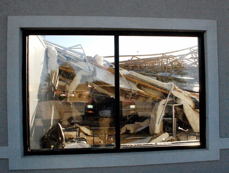Marc Hayot/Herald-Leader A view through a window at the Eastgate Shopping Center along U.S. Highway 412 in Siloam Springs shows the roof is missing and heavy damage inside the building after severe storms during the early hours of Monday morning.