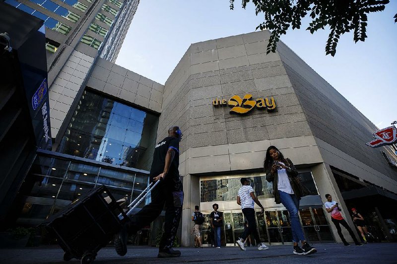 Pedestrians pass a Hudson’s Bay Co. store in Toronto in August. The Canadian department store chain has been struggling to lower its debt and stop its stock’s slide. 